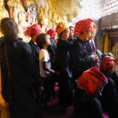 Shan women waiting to put gold leaf on Buddha figures