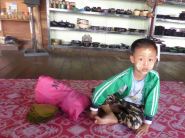 boy waiting for his mom to demo cheroot-making