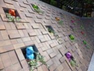 colourful plastic groundhogs poking heads out of brick